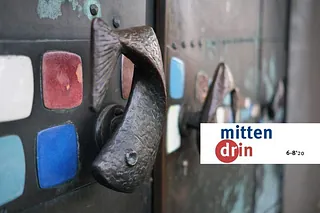 seitliche Nahaufnahme der Türgriffe in Fischform an der Kirchtür.
