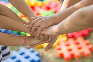 Aufeinander gelegte Hände von Jugendlichen