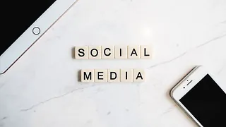 auf einer Mamorplatte liegen aus Scrabble Buchstaben die Worte Social Media