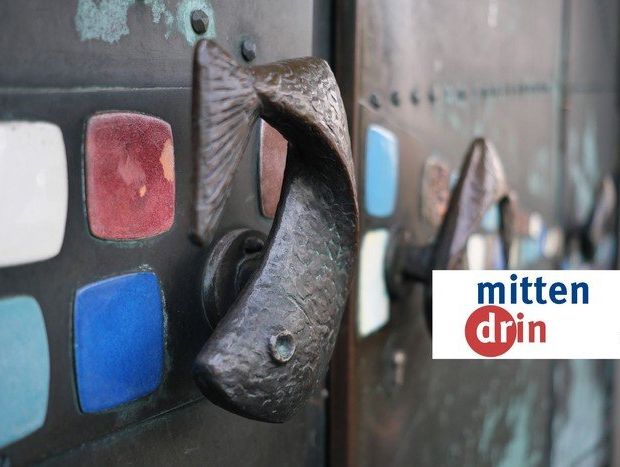 seitliche Nahaufnahme der Türgriffe in Fischform an der Kirchtür.