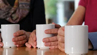 drei weiße Kaffeebecher, die gehalten werden
