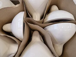 5 neue, verpackte Toiletten, liegend, mit Wellpappe getrennt