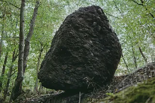 Großer Steinbrocken mitten im Wald auf dem Weg,