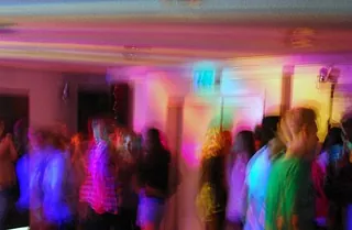 Verschwommene Aufnahme von Menschen in Diskolicht